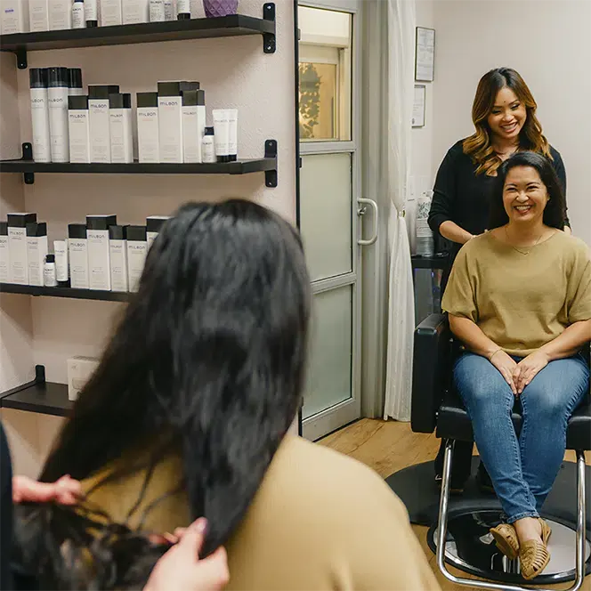 Hair Stylist Amy Soundara styling a happy woman's hair