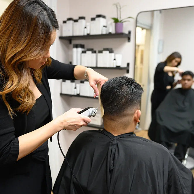 Hair Stylist Amy Soundara cuts a man's hair with trimmer